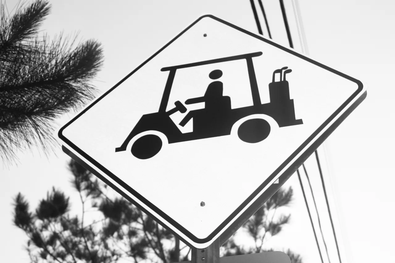 El carrito de golf remolcado por una manguera de jardín